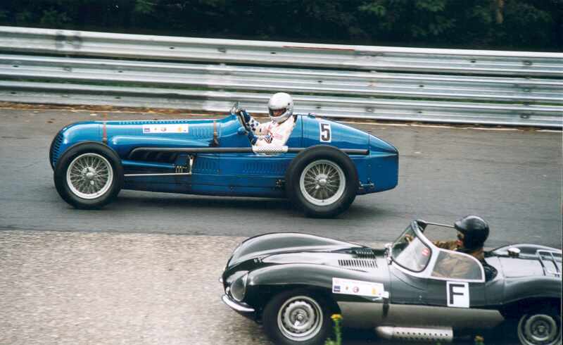 Zwei Oldtimer im Karussell. Whrend der Jaguar XKSS Rennsportwagen im Vorder-grund die Steilkurve benutzt, fhrt der Kollege mit dem blauen Maserati aus dem Jahre 1936  auen vorbei.
